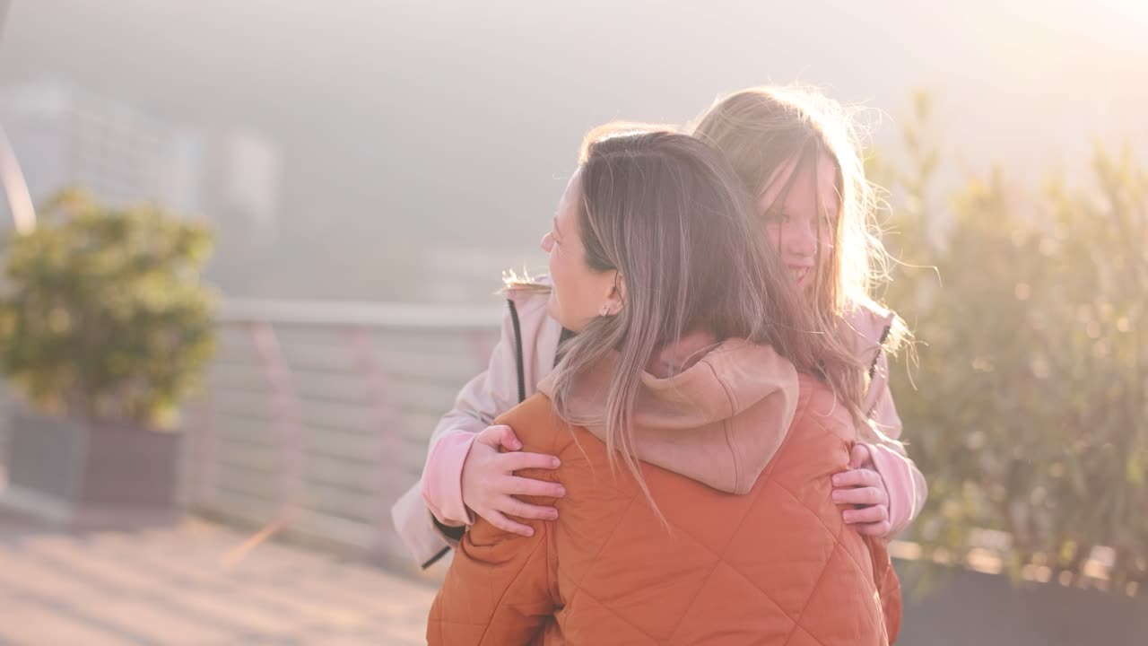 Una bambina corre gioiosamente verso la madre sorridendo raggiante.