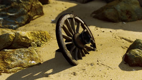 old wooden cart wheel at sand beach