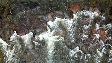 El-Agua-Fluye-Río-Abajo-A-Través-De-Suaves-Rocas-De-Río-Arremolinadas-Con-Cal