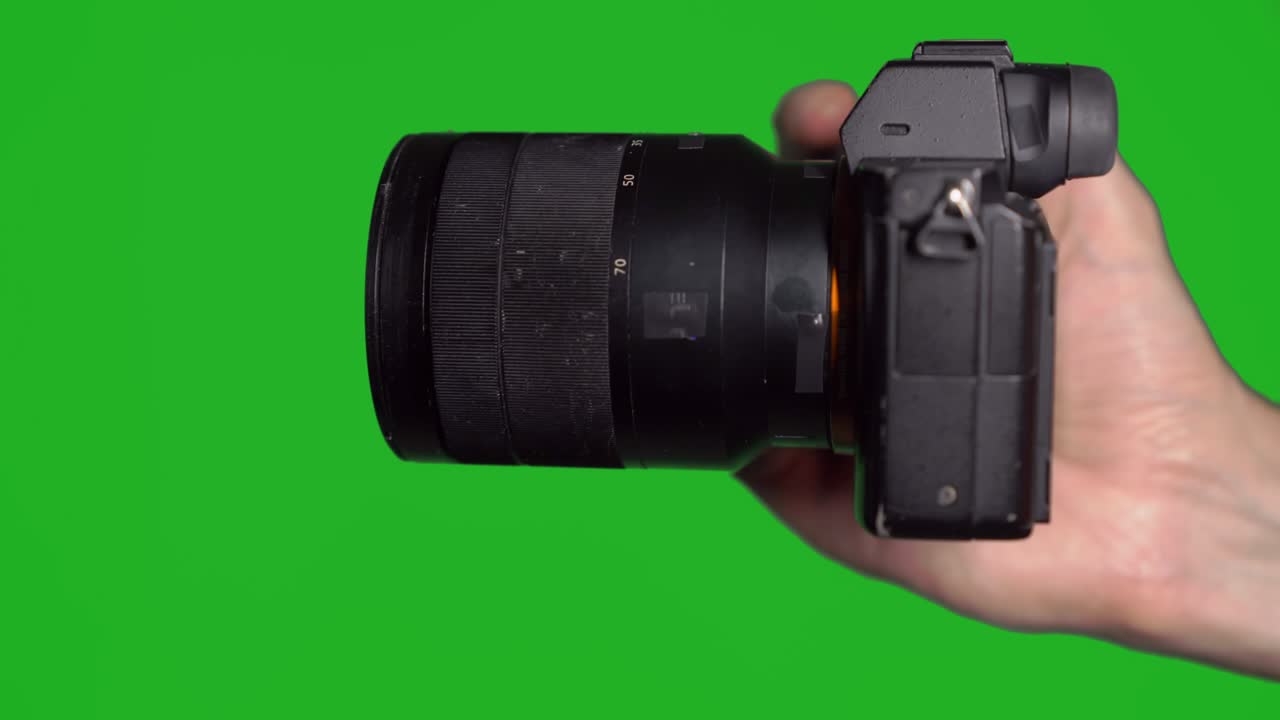 Professional DSLR photo camera with lens at green background. Chroma key