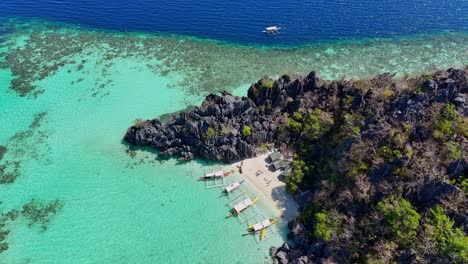 slow drone footage of a beach with boats on coron island in the philippines