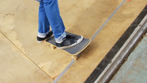 low section of young man doing skateboard trick on skateboard ramp at skateboard court 4k