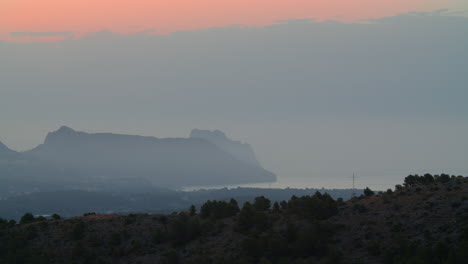 Mountains-and-town-on-sea-coast-misty-scene-in-Spain