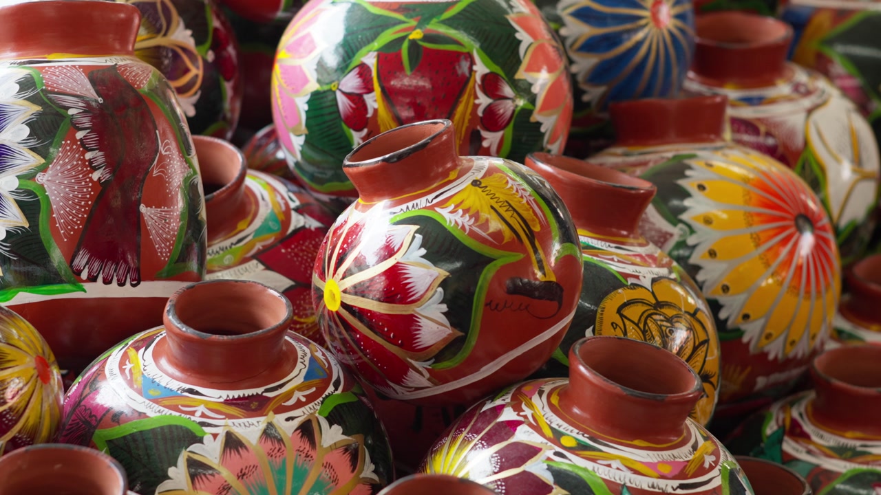Colorful hand painted clay pottery vases and decorative ceramic vessels displayed at Mexican artisan market, Palm Sunday Artisan Market