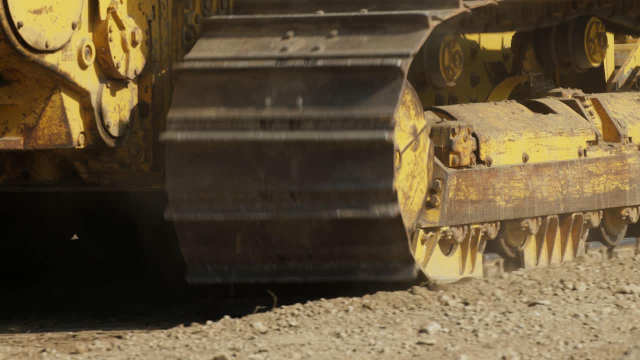 Close up of bulldozer tracks going backwards.