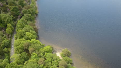 Paradiesische-Inseln,-Ruhige-Luftszene-Der-Schmalen-Kurvenreichen-Straße-Neben-Schönen-Klaren-Seen-Mit-Bergkette-Im-Hintergrund