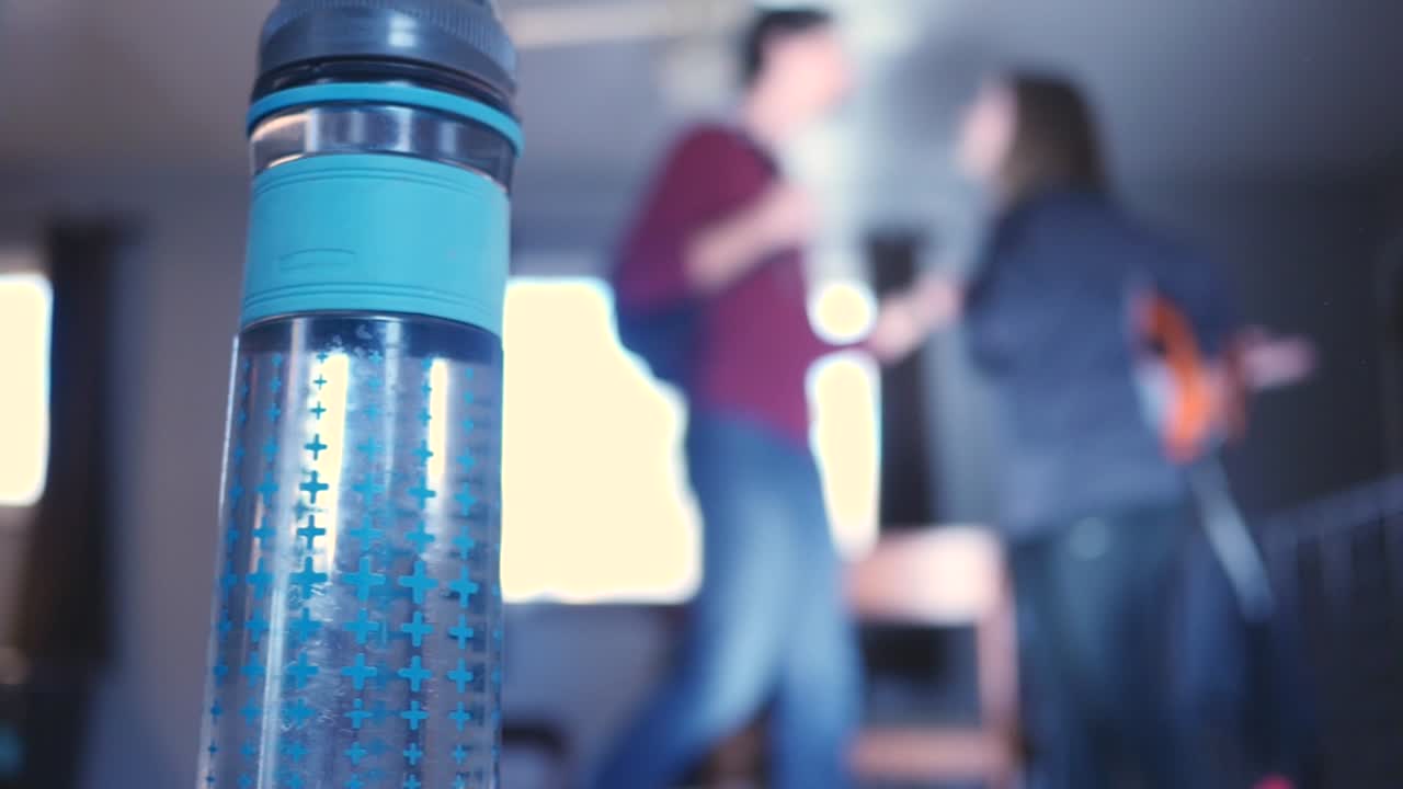 el hombre besa románticamente a la mujer antes de su viaje de aventura con la cámara de la botella de agua se mueve a cámara lenta 4k