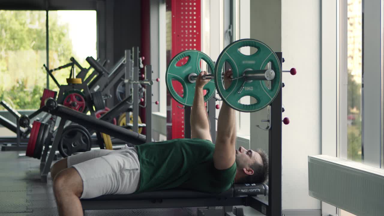 체육관 에서 벤치 프레스 를 하는 남자