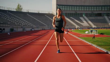 woman running on a track in a stadium