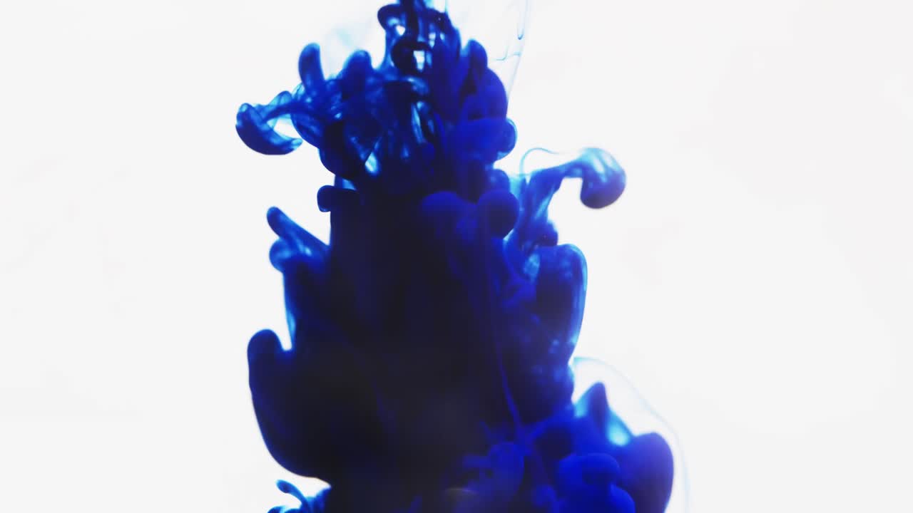 Slow motion video of blue watercolor ink mixing in water against grey background