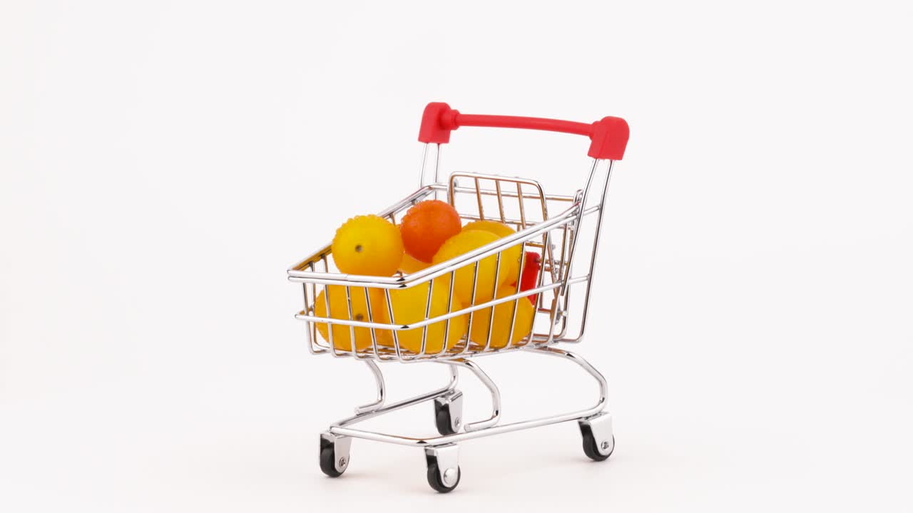 노란색 포도 토마토와 물방울이 쌓인 쇼핑 카트, 회전 테이블에서 회전, 색 배경에서 고립, 클로즈업, 매크로.