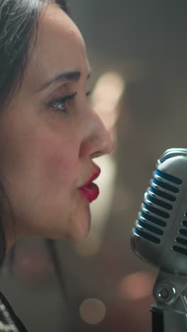 intenso primer plano de una vocalista femenina cantando en un micrófono vintage, ambientado contra un fondo suavemente borroso