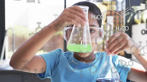 conducting chemistry experiment, child holding flask with chemical formulas over