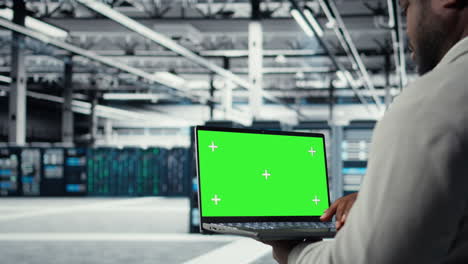 data center programmer working on green screen laptop, updating storage