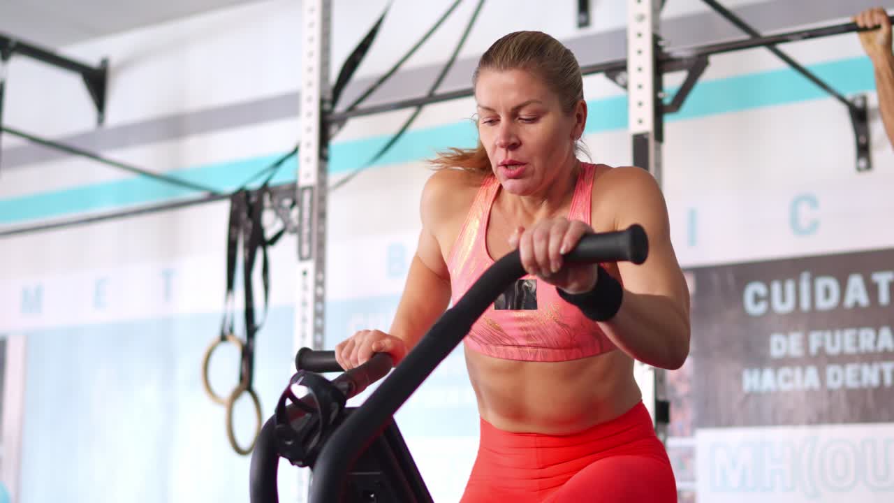 Donna determinata che si allena su air bike in palestra
