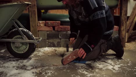 hombre limpiando ladrillo rojo usado con martillo de garra en una casa de granja