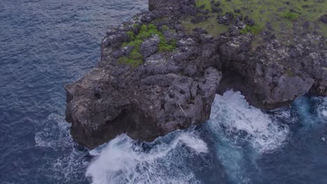 rocky coastline with small waves at sumba island indonesia during sunrise, aerial