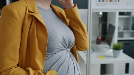 pregnant woman talking on phone in modern office