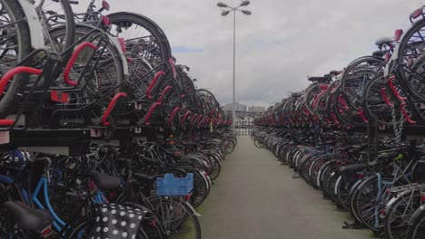 Zeitlupenschwenk-Von-Geparkten-Fahrrädern-Im-Fahrradständer-In-Amsterdam,-Niederlande