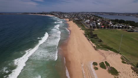 sea waves splashing sandy shore of stockton beach in new south wales, australia - drone shot