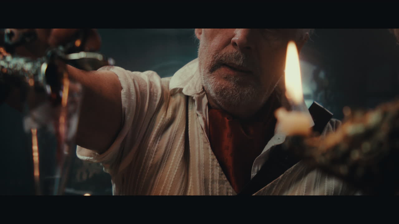 An old pirate eats and drinks inside the sailing ship cabin