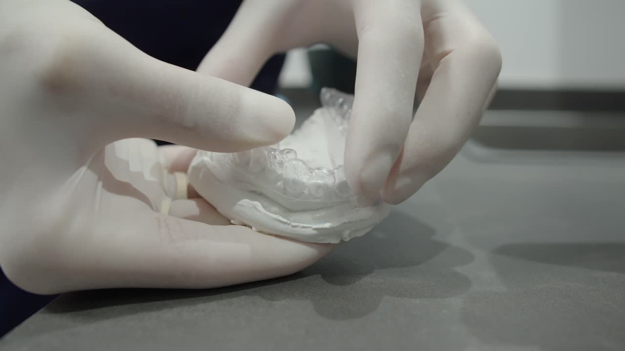 fotografía de cerca de un ortodontista que muestra un aparello ortopédico invisible