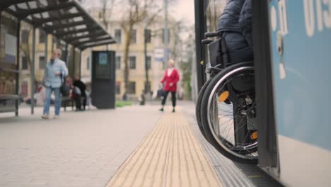 person with a physical disability enters public transport with an accessible ramp