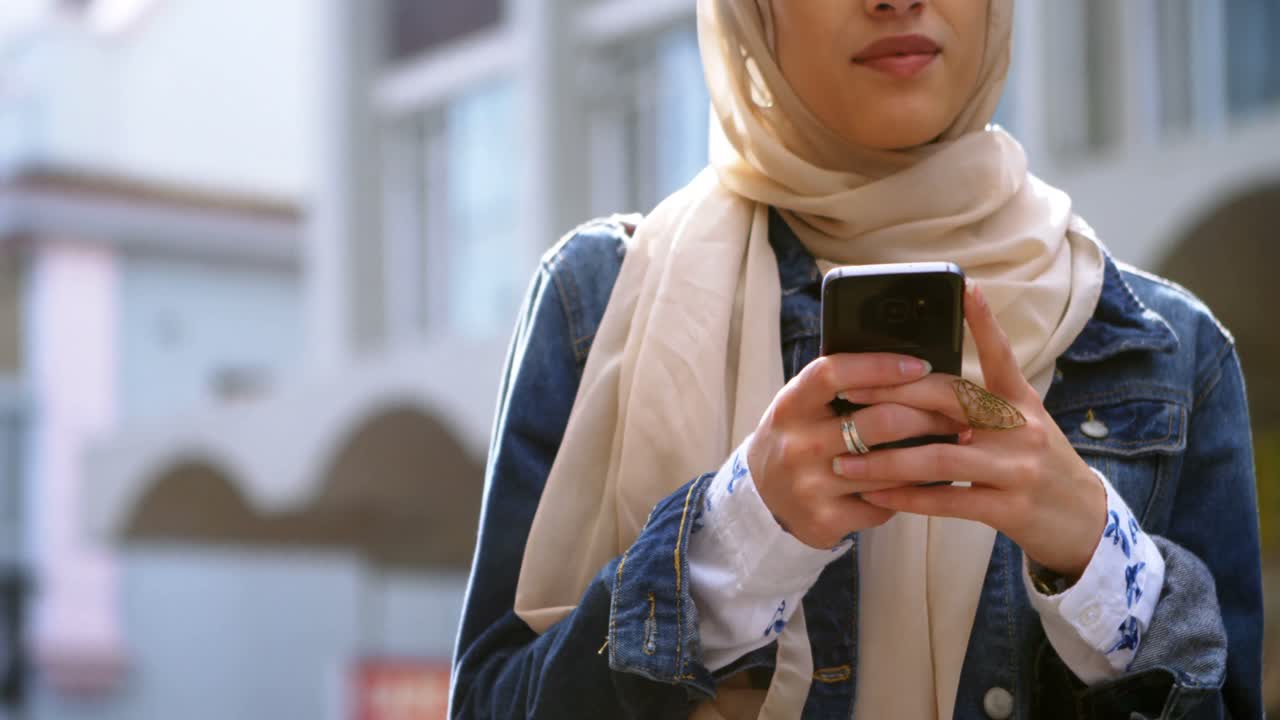 Woman in hijab using mobile phone 4k