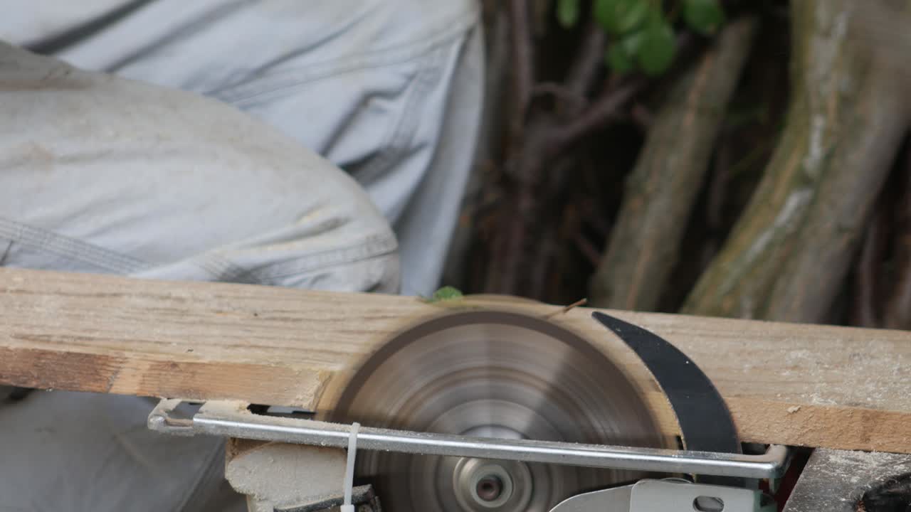 3 in 1 Men's gloved hands sawing firewood and puts them in buckets.