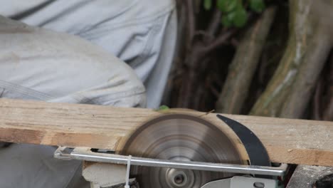 3 in 1 men's gloved hands sawing firewood and puts them in buckets.