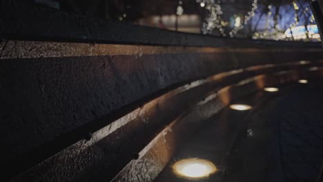 Water-Falling-Down-a-Concrete-Wall-being-Illuminated-by-Ground-Lights-on-a-Rainy-Night