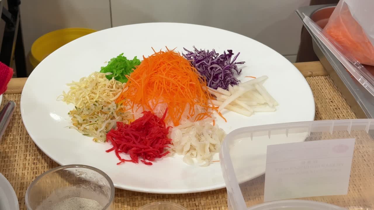 A close-up of a chef preparing the ingredients of yusheng, yee sang or yuu sahng or Prosperity Toss in a Malaysian restaurant