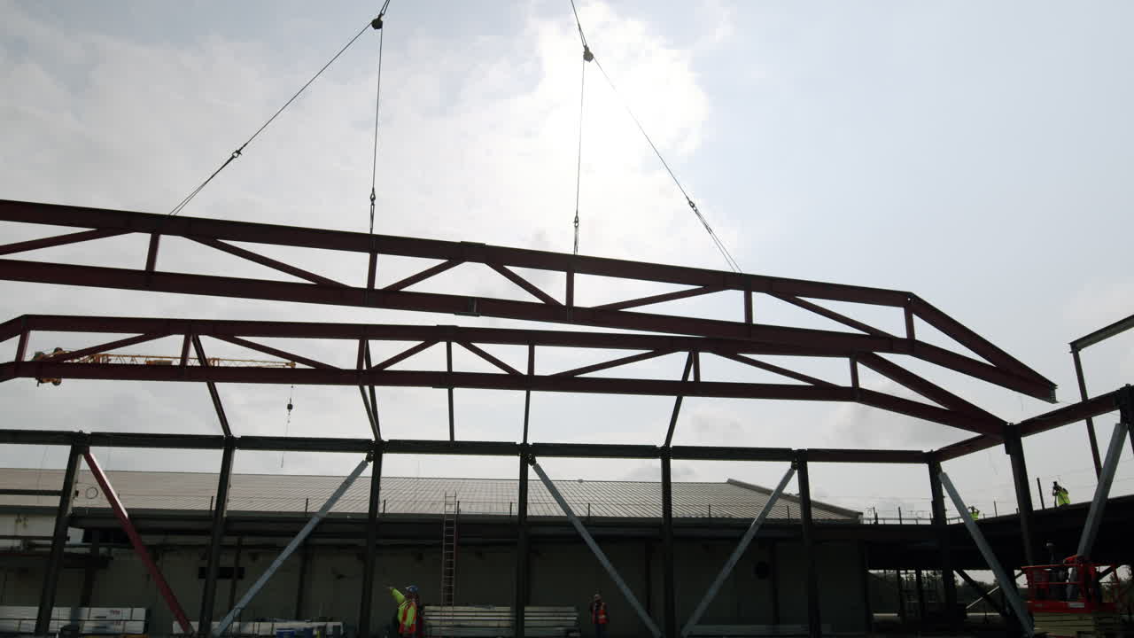 Steel frame being lifted by a crane at a construction site