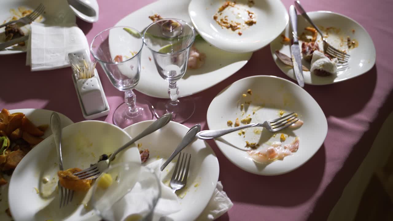 leftovers on white dishes are on the festive table. Camera motion forward