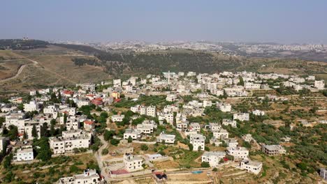 aerial view of a village or town in a hilly landscape with scattered buildings
