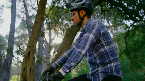hombre usando smartwatch mientras está sentado en una bicicleta 4k