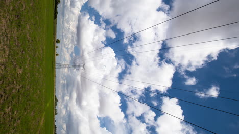 Symmetrische-Strommasten-Mit-Natürlichen,-Kraftvollen-Wolkenformationen,-Die-Von-Menschenhand-Geschaffene-Und-Wunderschöne-Naturenergie-Zeigen