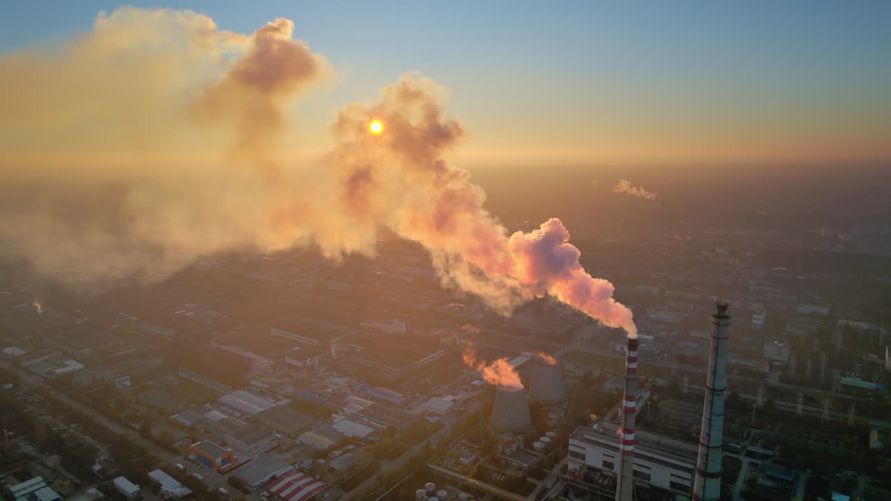 Aerial drone view of thermal power plant in Chisinau at sunset, Moldova. View of pipes with felling steam, cityscape