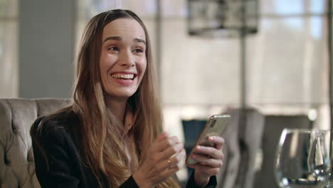 excited woman using smartphone in restaurant. business woman enjoy good news