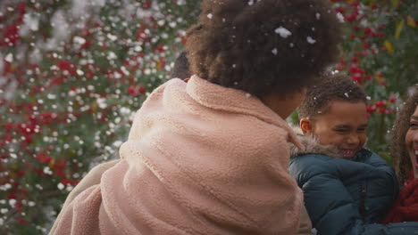 family having fun playing in snow on winter walk in countryside - shot in slow motion