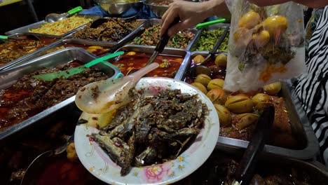 person serving various dishes at a buffet