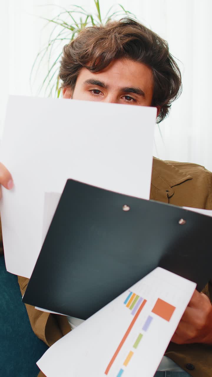 Happy man freelancer work with documents from home analyzing information prepare financial report