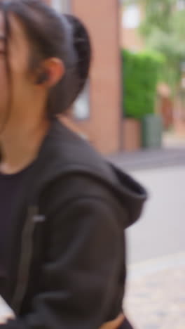 Vertical-Video-Of-Young-Woman-Exercising-Running-Along-Urban-Street-Wearing-Wireless-Earbuds-Shot-In-Real-Time-2