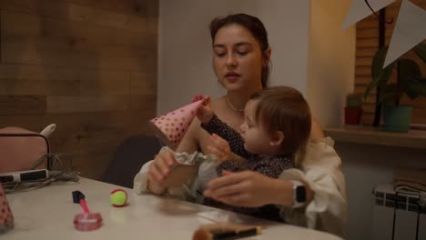 mother and baby playing with makeup and mobile phone