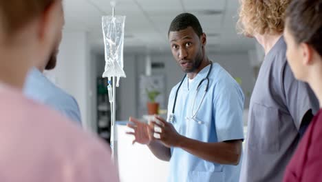 African-american-male-doctor-training-diverse-trainee-doctors,-applying-drip,-slow-motion