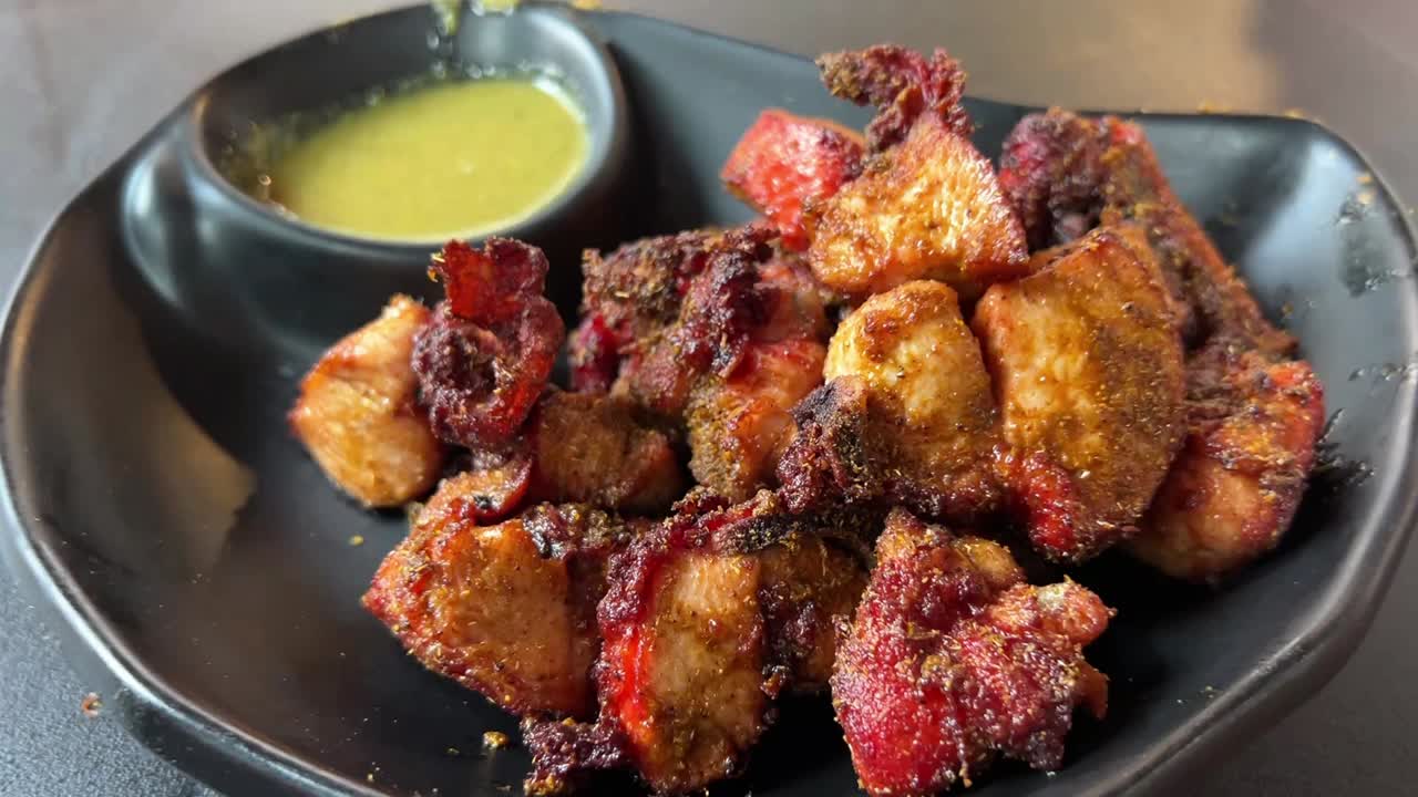 Chicken changezi with dhaniya sauce served in a black plate.