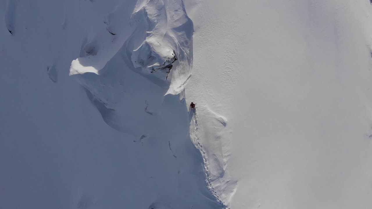 tiro de drone de snowboarder caminando sobre una cresta peligrosa en austria