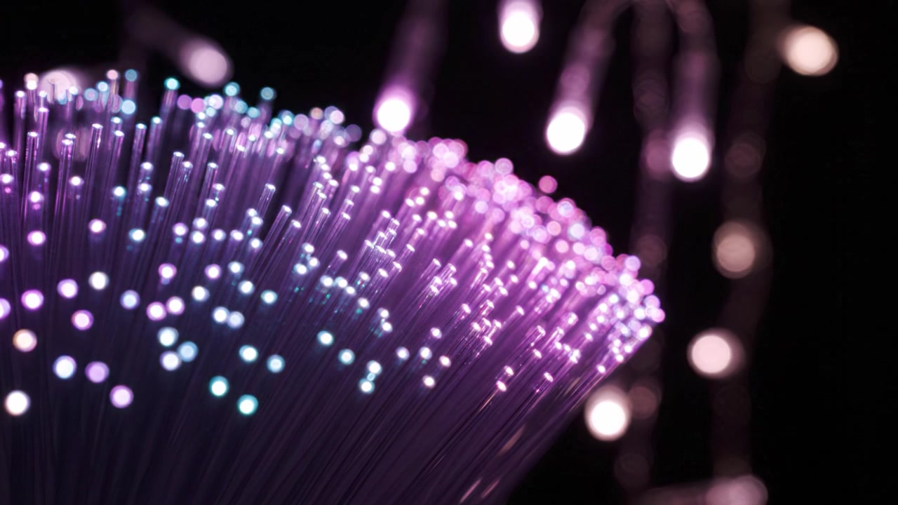 A stunning close-up of illuminated fiber optic strands and colorful lights, showcasing intricate details of vibrant hues blending in a mesmerizing display of technology.