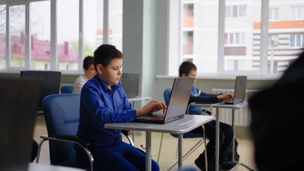 Students working on laptops in a computer class