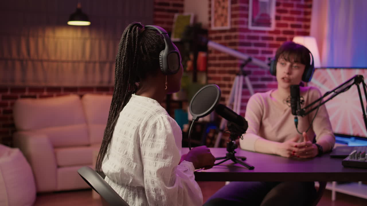 African american influencer talking in interview with smiling online radio host using professional microphone